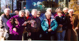 Group of seniors standing outdoors on a sunny day standing in 2 rows facing camera